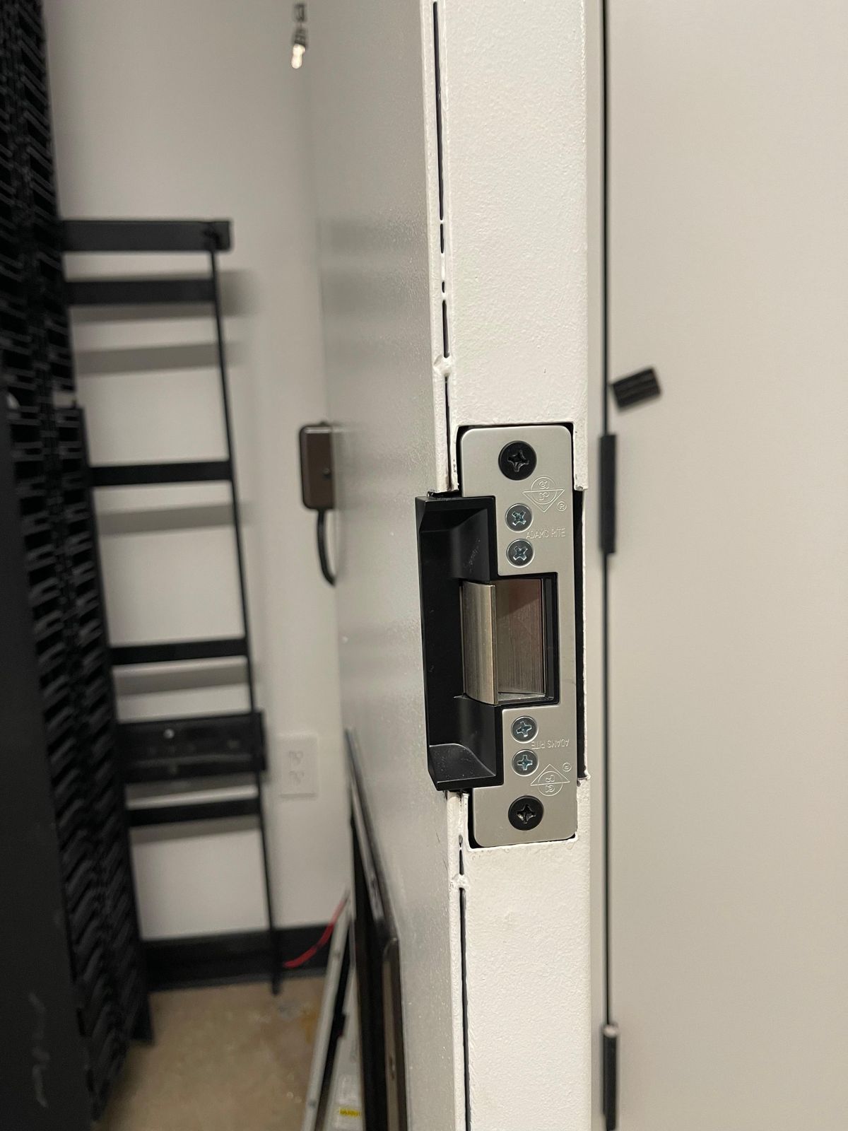 Electric strike installed on the data-closet door frame, wired into the access control system